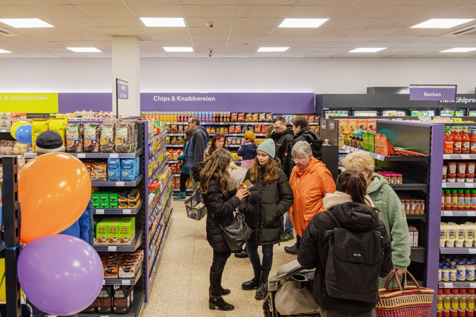Menschen treffen sich in einem Tante Enso-Laden und unterhalten sich.